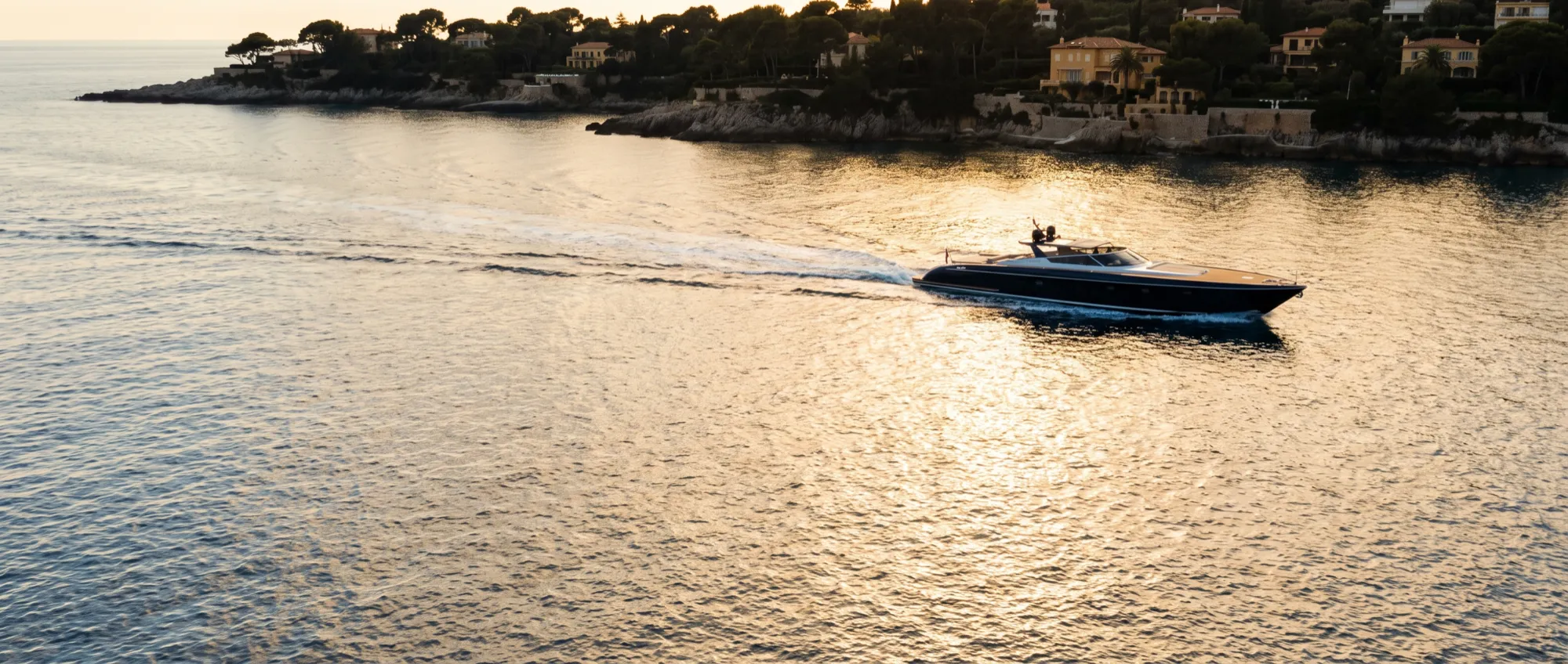 A day boat running home along the coast with the light going gold.