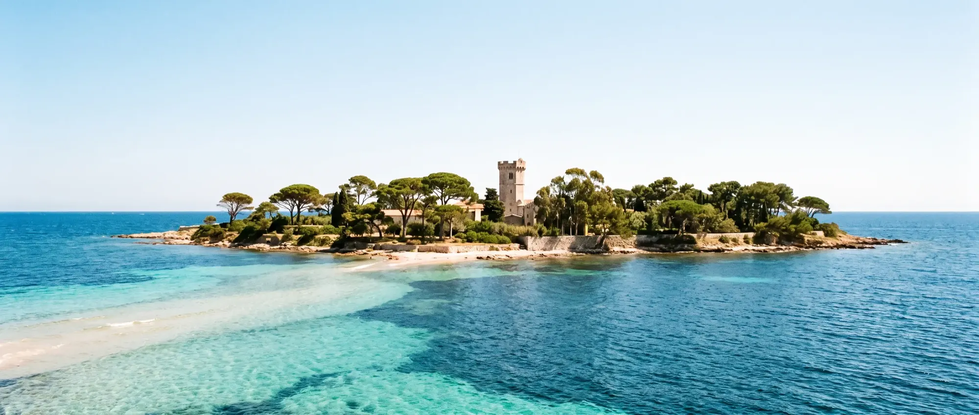 Banded turquoise water over sand between the wooded Lérins islands.