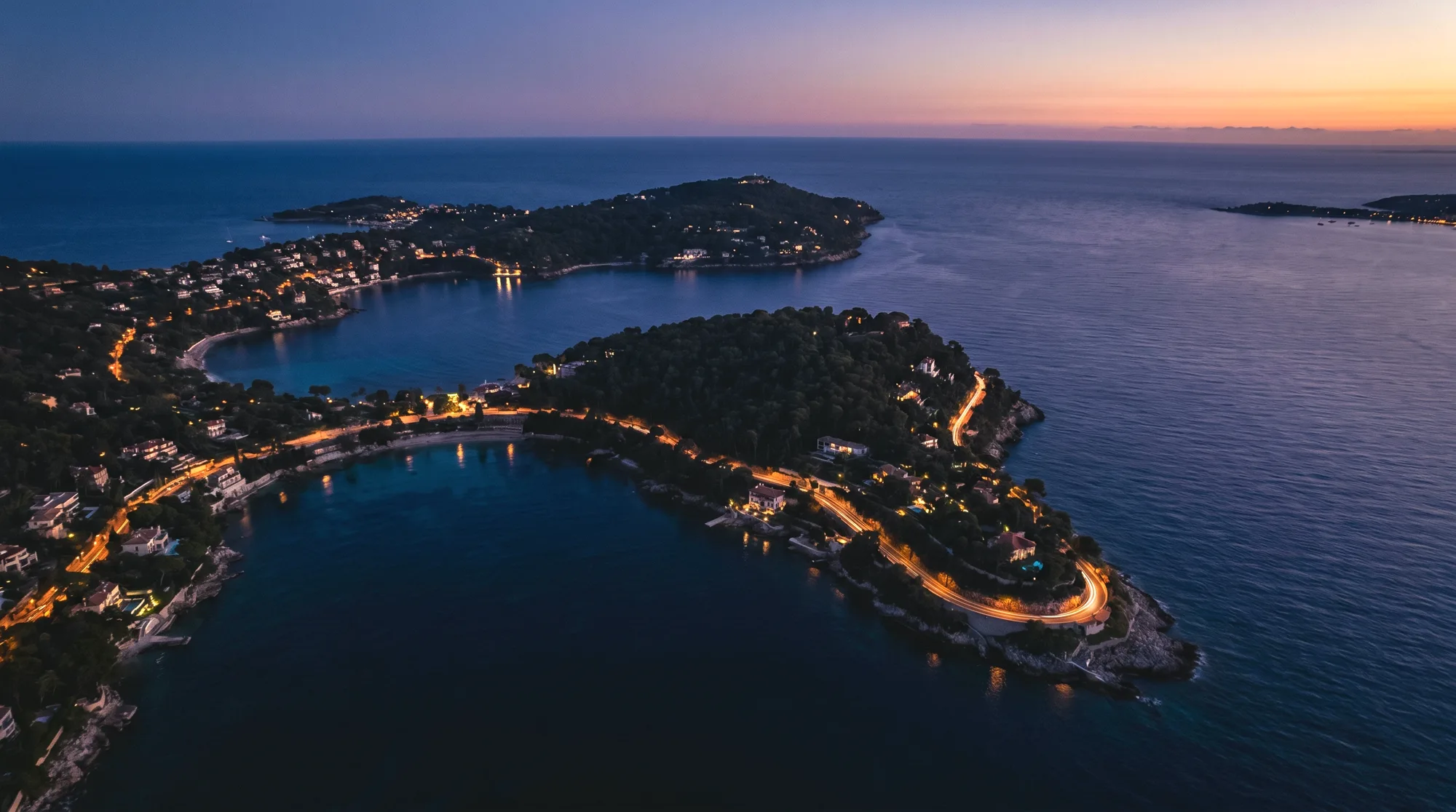 The Cap Ferrat peninsula from the air at blue hour.